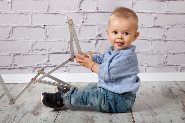 Child playing with wooden meter stick — Stock Photo
