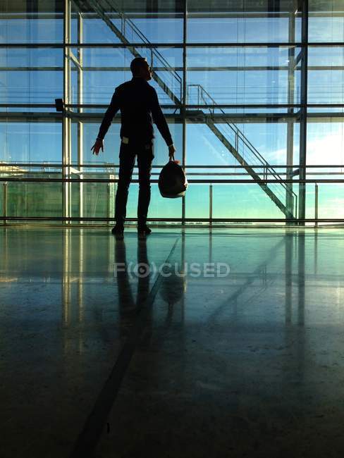 Человек, стоящий у окна в аэропорту — стоковое фото