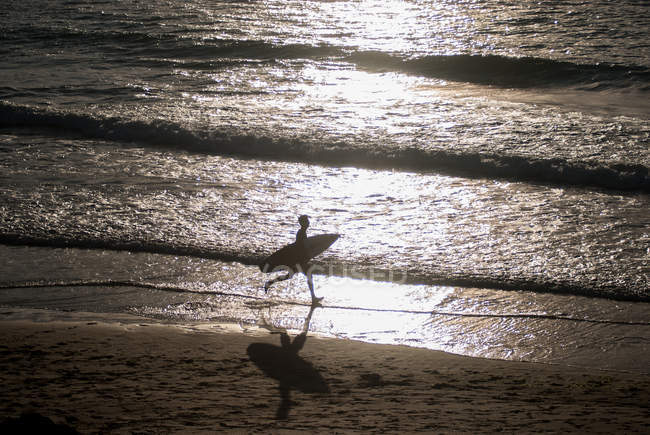Surfista correndo na praia — Fotografia de Stock