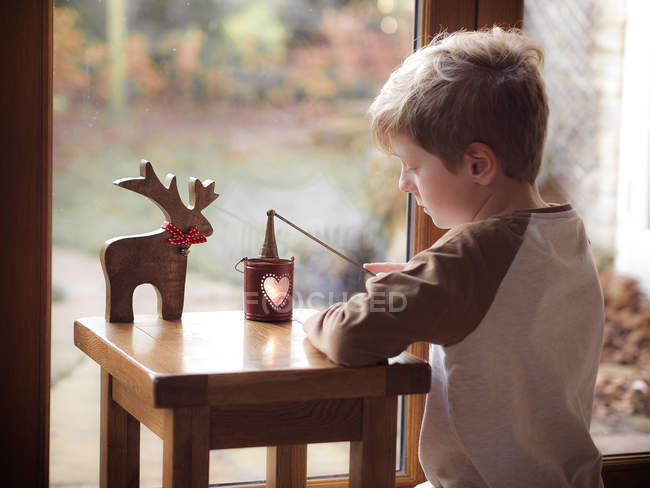 Junge löscht Kerze aus Laterne — Stockfoto