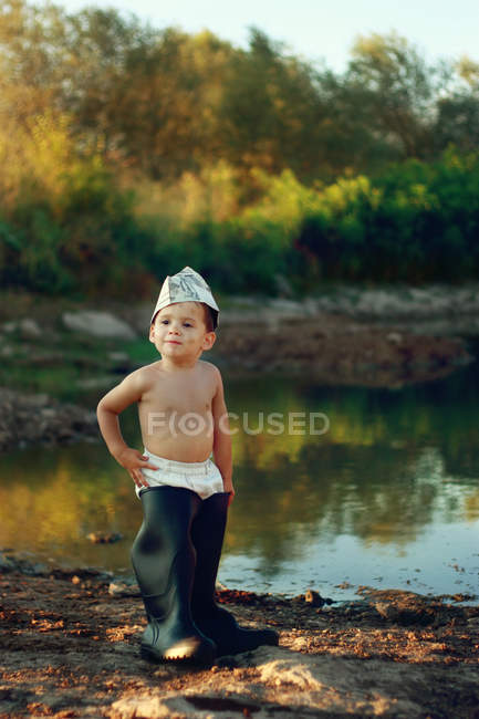 Niño usando enormes botas de goma - foto de stock