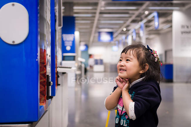 Menina em pé por máquina de venda automática — Fotografia de Stock