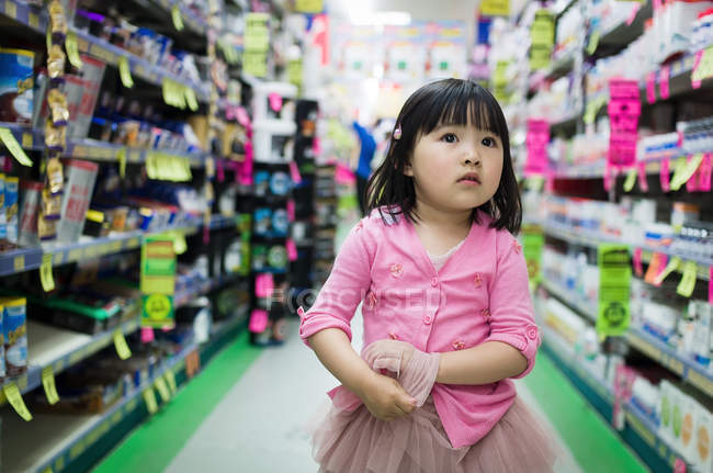 Small girl walking between stalls — Stock Photo
