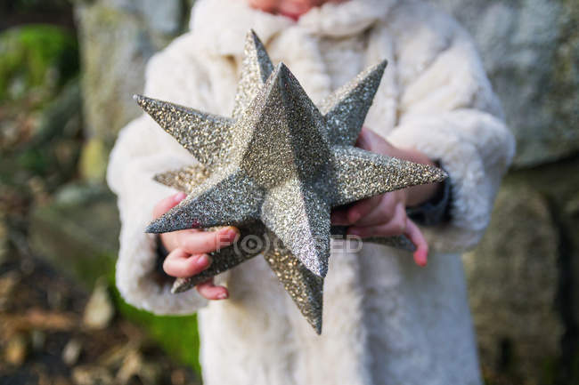Girl holding star covered — Stock Photo