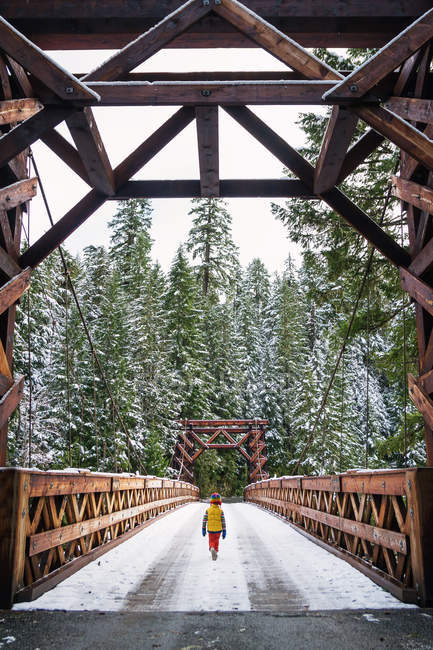 Boy walking across bridge — Stock Photo