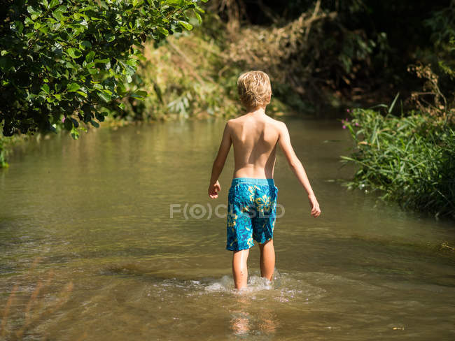 Ragazzino che cammina nel torrente — Foto stock