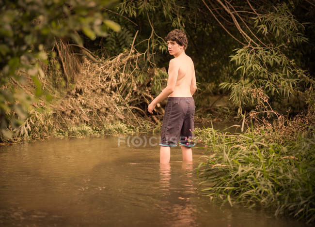 Rapaz em pé no riacho — Fotografia de Stock