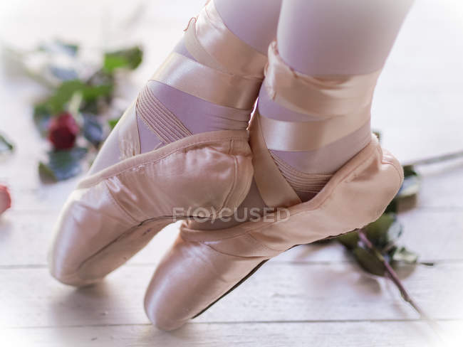 Fille en chaussures de ballet avec les pieds croisés — Photo de stock