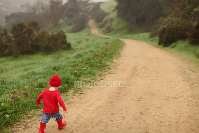Хлопчик, гуляючи по сільській дорозі — стокове фото