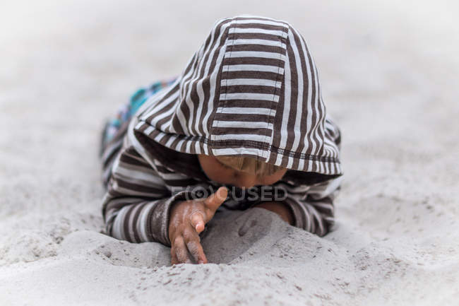 Мальчик играет в песок — стоковое фото