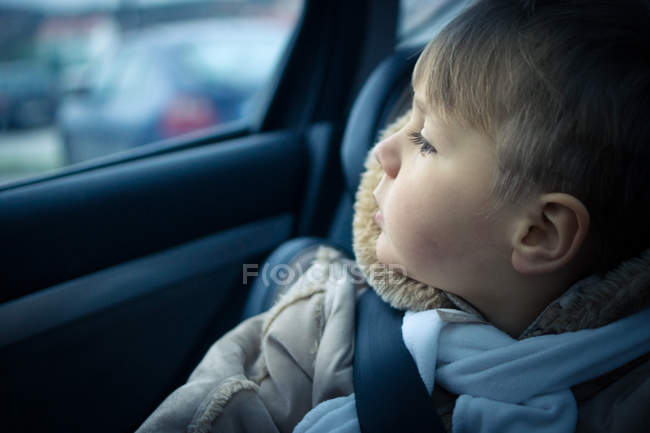 Niño en asiento de coche - foto de stock