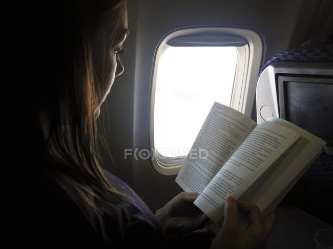 Woman reading in flight — Stock Photo
