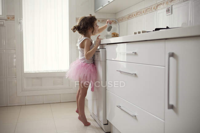Chica en la cocina doméstica - foto de stock