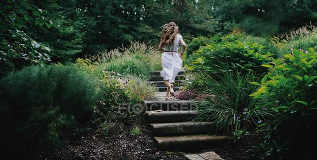 Mujer corriendo en el jardín - foto de stock