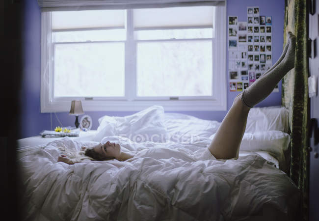 Jeune femme couchée sur son lit — Photo de stock