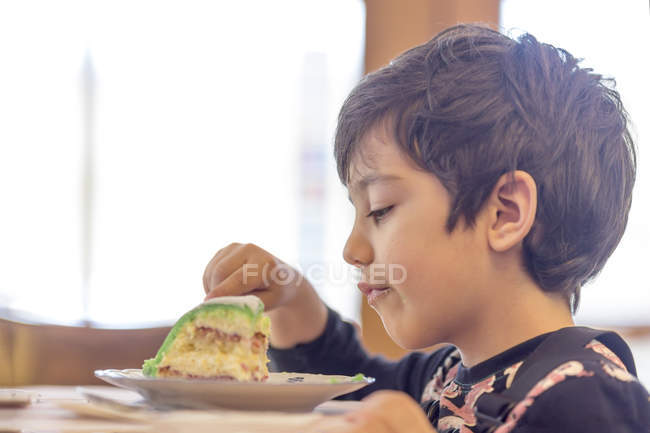 Мальчик ест торт — стоковое фото