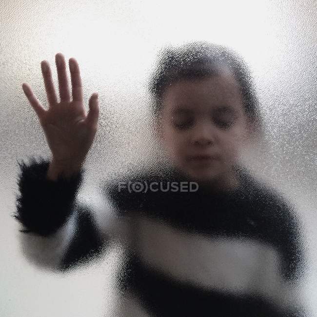 Девушка трогает матовое стекло — стоковое фото