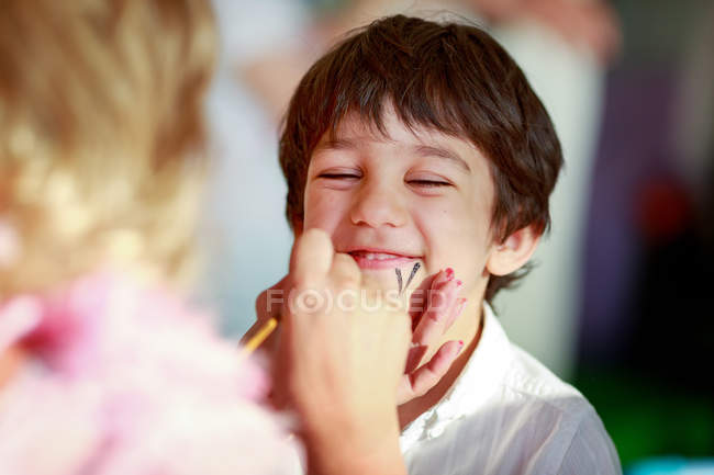 Young boy getting his face painted — Stock Photo