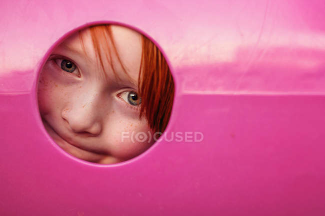 Joven niño espiando a través del agujero - foto de stock