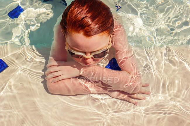 Giovane ragazzo a riposo in piscina — Foto stock