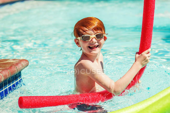 Молодий хлопчик грає в басейні — стокове фото
