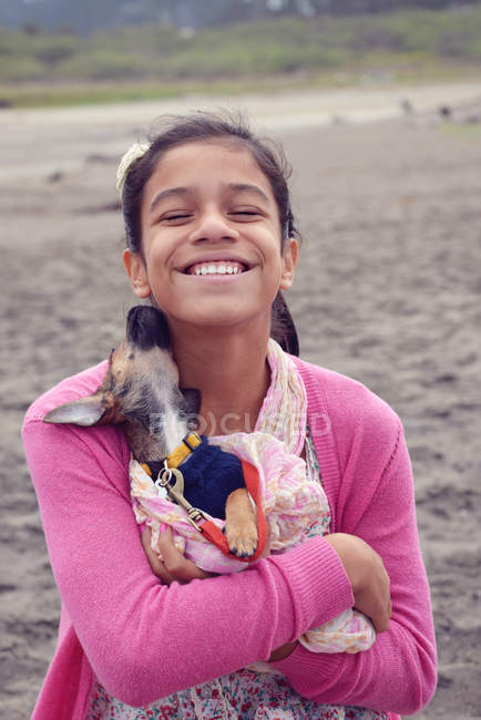 Lächelndes Mädchen kuschelt Welpen — Stockfoto