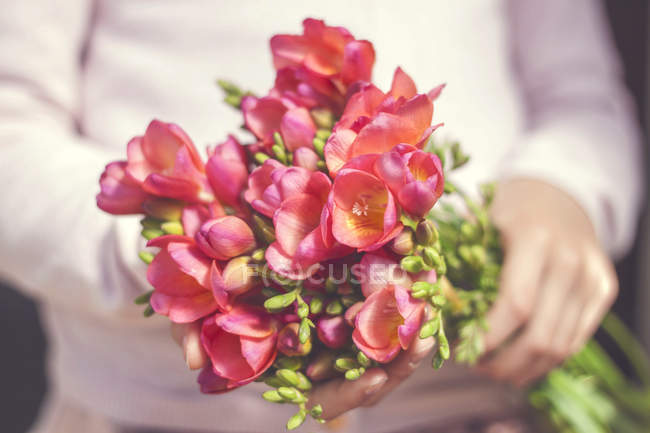Woman holding bunch of flowers — Stock Photo