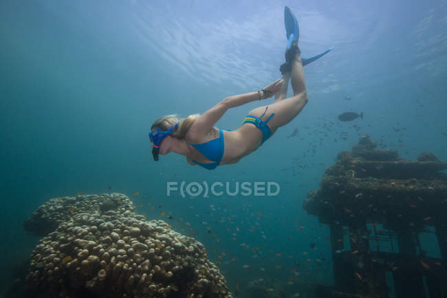 Woman snorkeling exploring sunken temple — Stock Photo