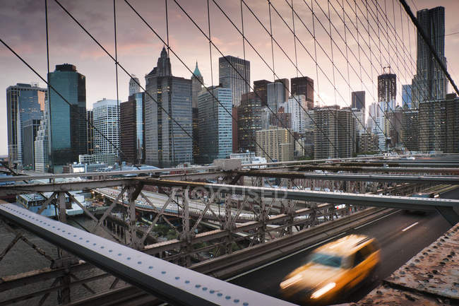 Taxi amarillo cruzando el puente de Brooklyn - foto de stock