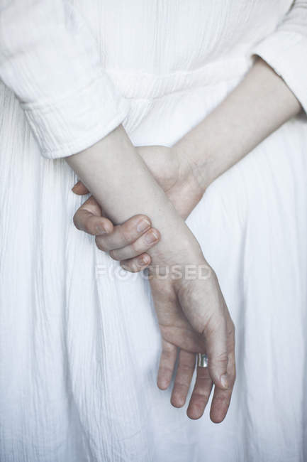 Donna che si tiene per mano dietro la schiena — Foto stock