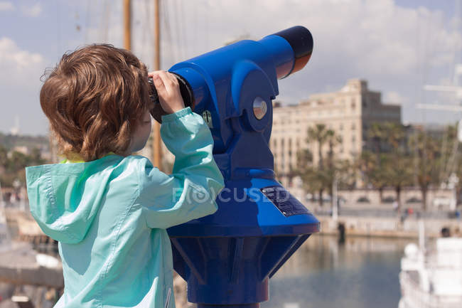Niño mirando a través de prismáticos - foto de stock