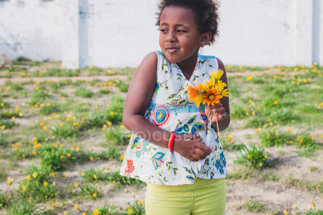 Menina segurando monte de flores — Fotografia de Stock