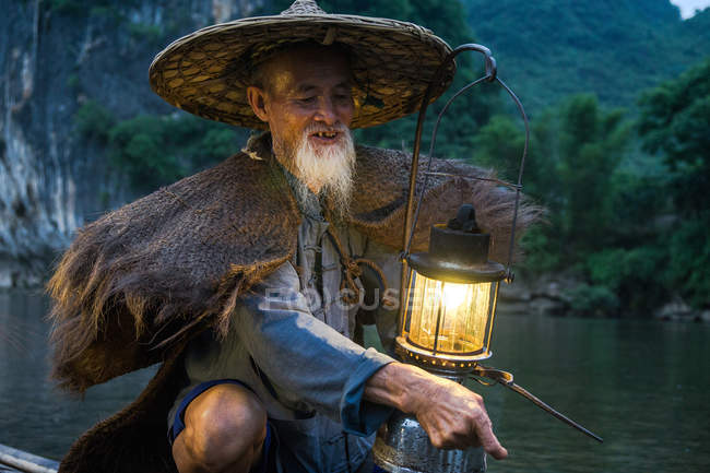 Antiguo pescador chino con linterna - foto de stock