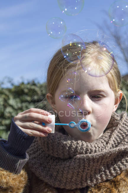 Chica soplando burbujas - foto de stock