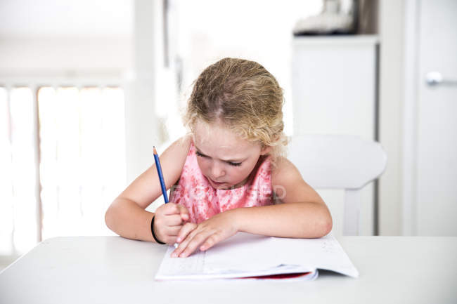 Mädchen reibt Hausaufgaben aus — Stockfoto