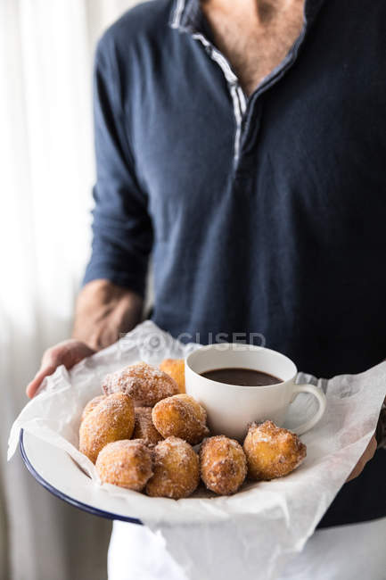 Man holding plate of donuts — Stock Photo