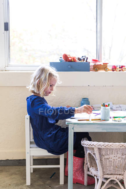 Маленька дівчинка малює на столі — стокове фото