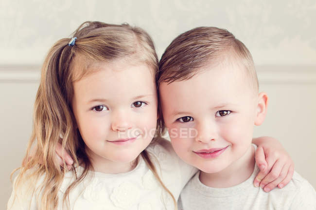 Chica y niño abrazando - foto de stock