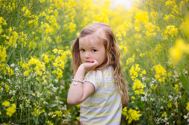 Girl in meadow of yellow flowers — Stock Photo