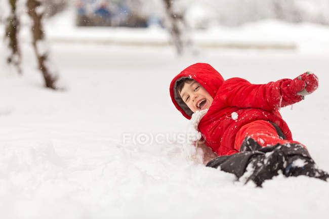 Garçon jouant dans la neige — Photo de stock