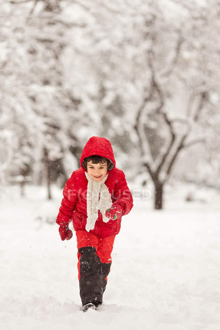 Niño corriendo en la nieve - foto de stock