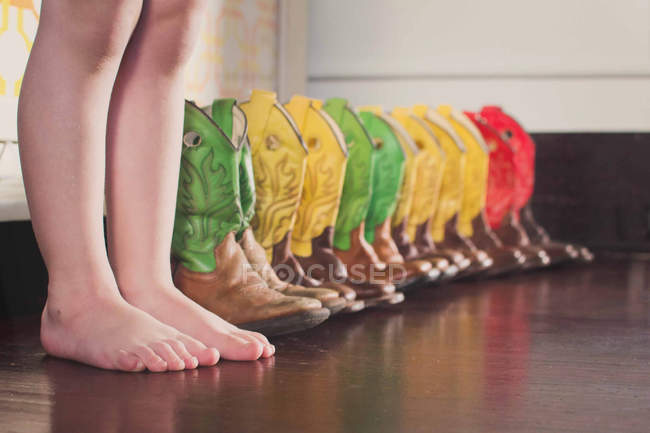 Хлопчик з барвистими ковбойськими черевиками — стокове фото