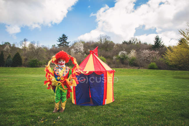 Мальчик стоит перед цирковой палаткой — стоковое фото
