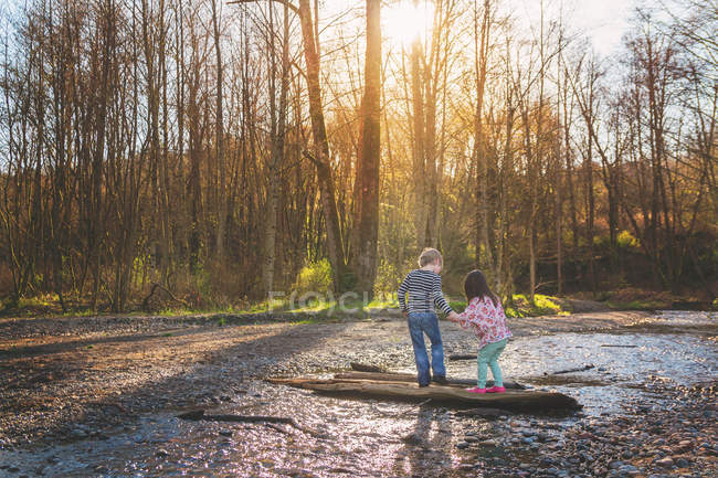 Boy helping girl walk — Stock Photo