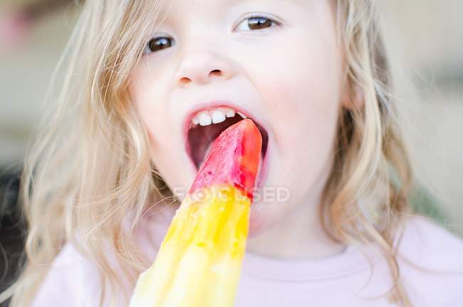 Menina comendo um gelo alegre — Fotografia de Stock