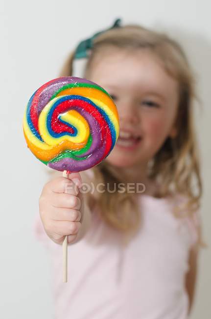 Девушка держит разноцветный леденец — стоковое фото