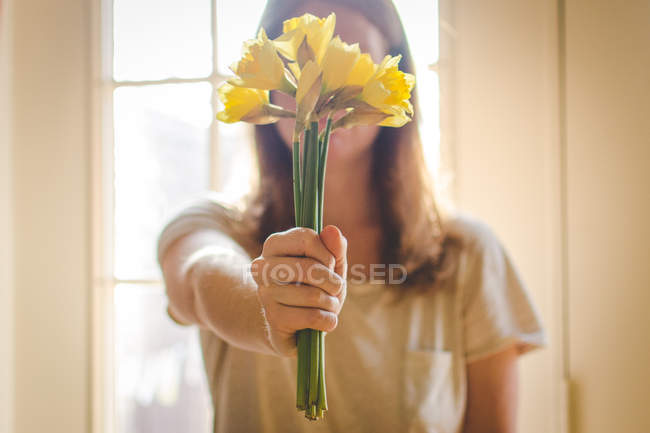 Frau hält Strauß Narzissen in der Hand — Stockfoto