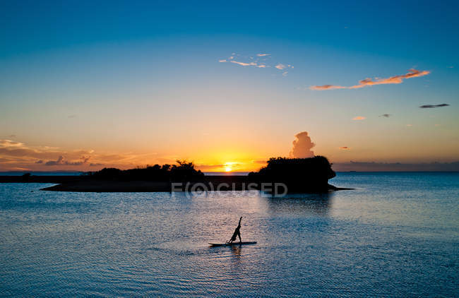 Mulher praticando ioga no paddleboard — Fotografia de Stock