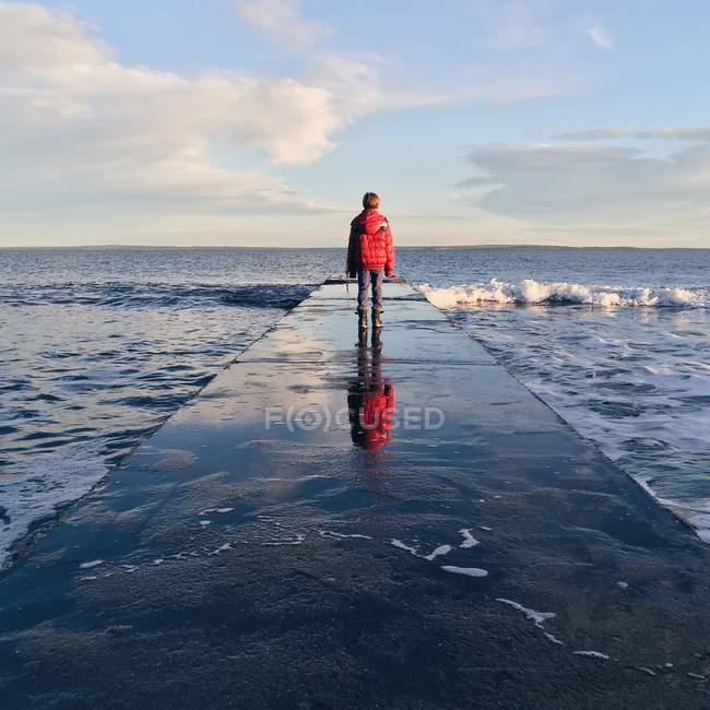 Boy standing on jetty — Stock Photo