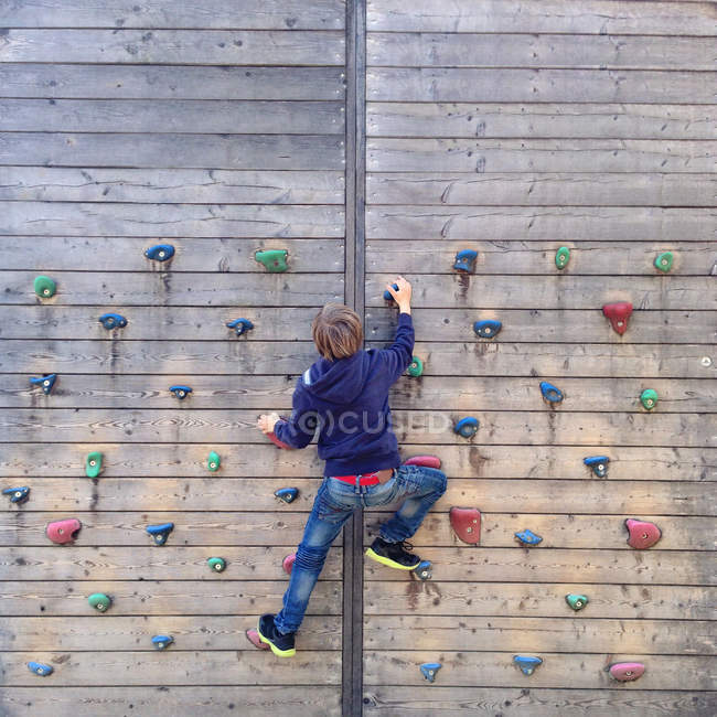 Ragazzo arrampicata sulla parete di arrampicata — Foto stock